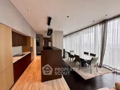 Luxurious open-plan living and dining area with floor-to-ceiling windows and modern kitchen.