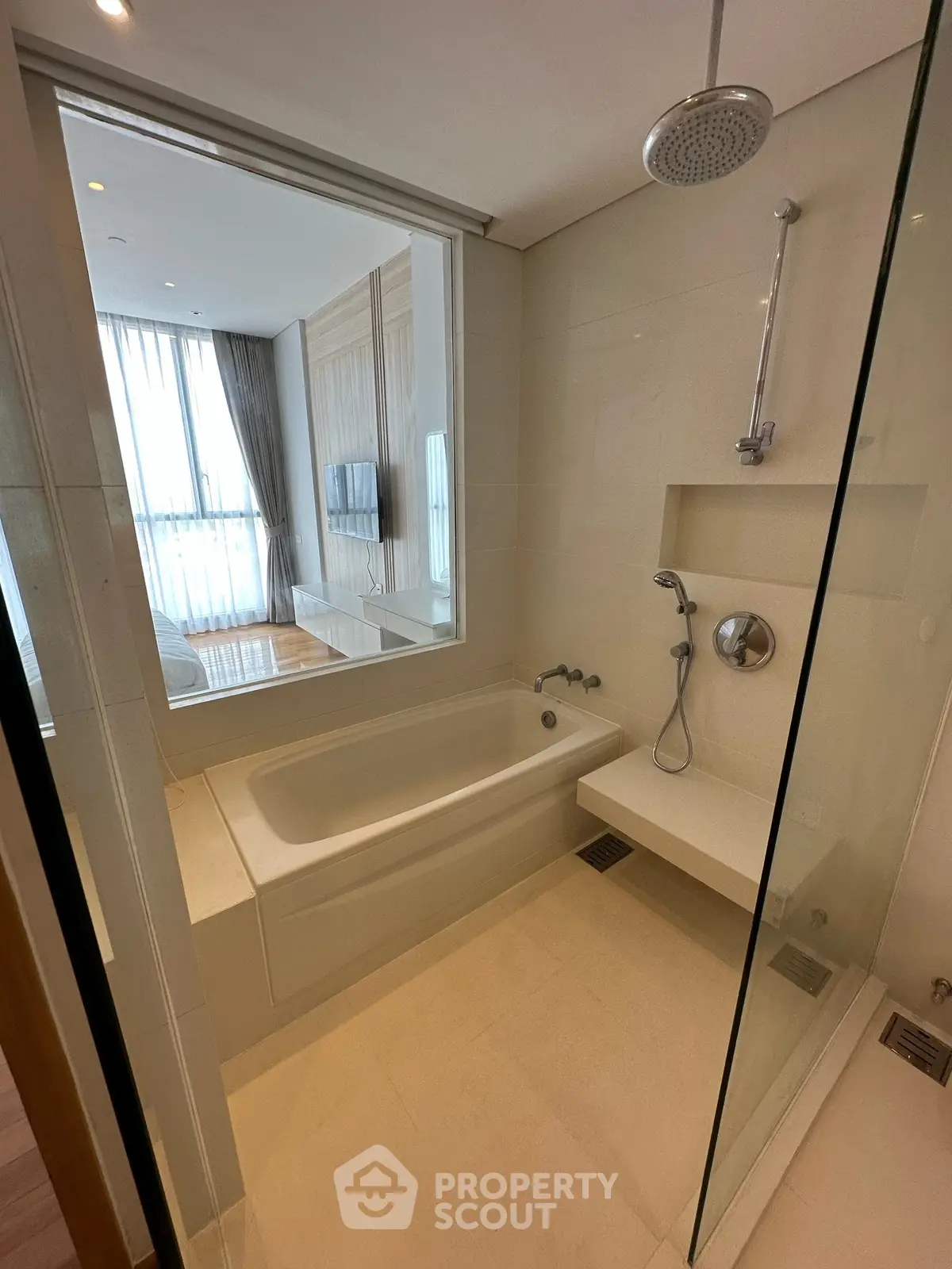 Modern bathroom with glass shower and bathtub in luxury apartment