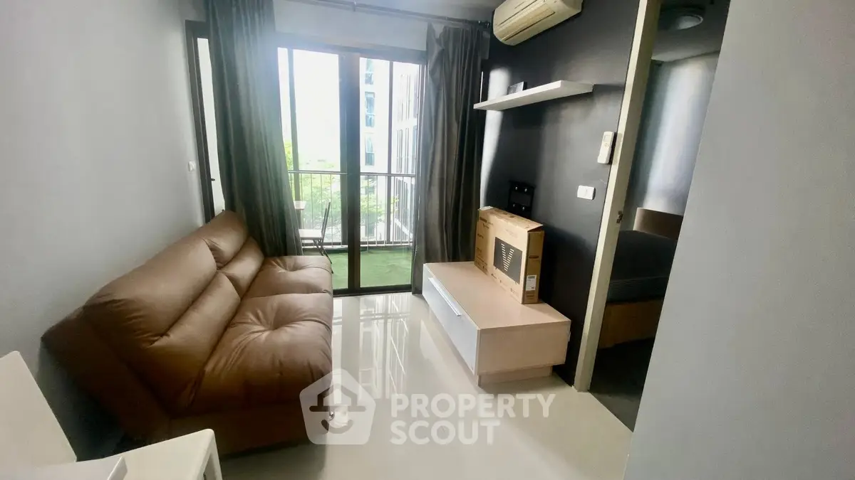 Modern living room with brown sofa and balcony view in a stylish apartment.