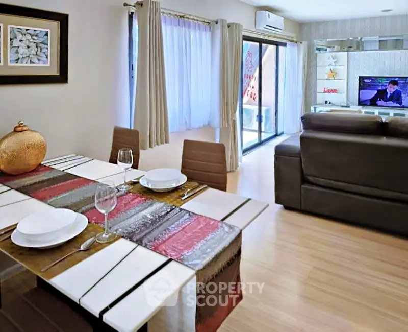 Modern living room with dining area, featuring stylish decor and natural light.