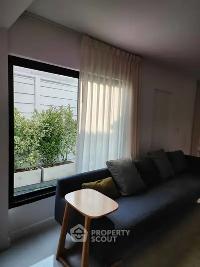 Modern living room with large window and stylish sofa