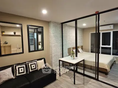 Modern studio apartment with glass partition, cozy living area, and stylish bedroom.