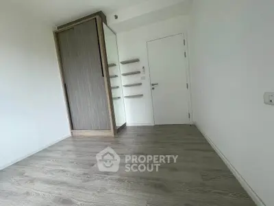 Minimalist empty room with wooden flooring and built-in wardrobe