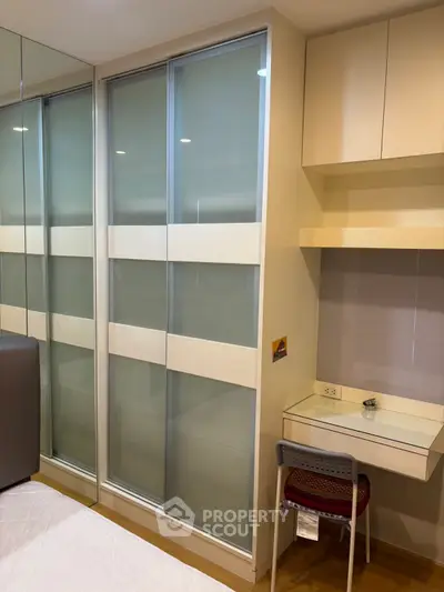 Modern bedroom with built-in closet and compact study area, perfect for urban living.