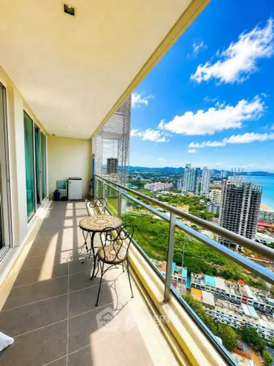 Stunning high-rise balcony with panoramic city and ocean views, perfect for relaxation and entertainment.