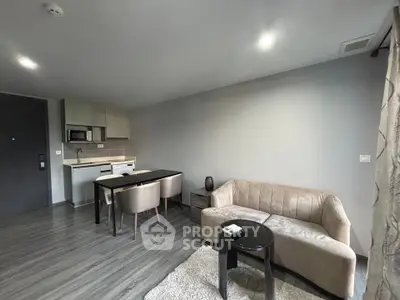 Modern living room with open kitchen layout, stylish furniture, and cozy ambiance.