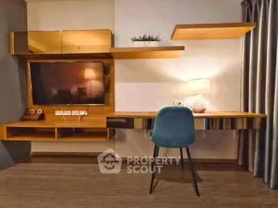 Modern study area with sleek desk, wall-mounted TV, and stylish chair in a contemporary apartment.