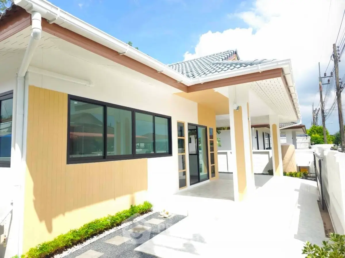 Modern single-story house with large windows and a spacious patio, perfect for family living.