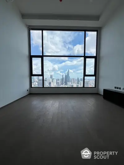 Spacious room with stunning city skyline view through large windows.