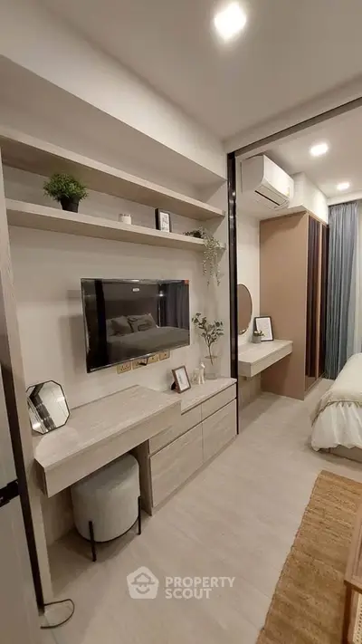 Modern bedroom with built-in shelves, TV, and stylish decor