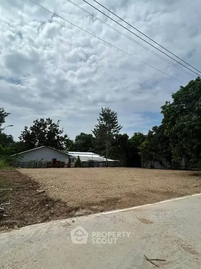 Spacious vacant land plot with potential for development, surrounded by lush greenery and a serene environment.