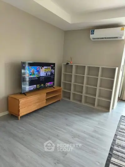 Modern living room with sleek TV setup and stylish shelving unit.