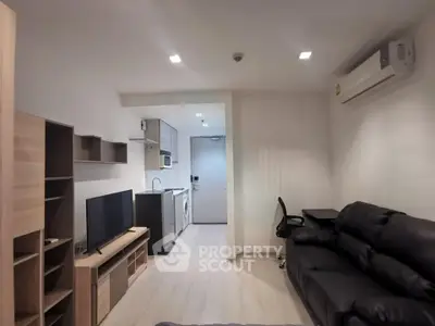 Modern living room with sleek furniture and integrated kitchen appliances in a cozy apartment.