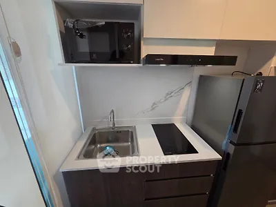 Modern compact kitchen with sleek appliances and minimalist design