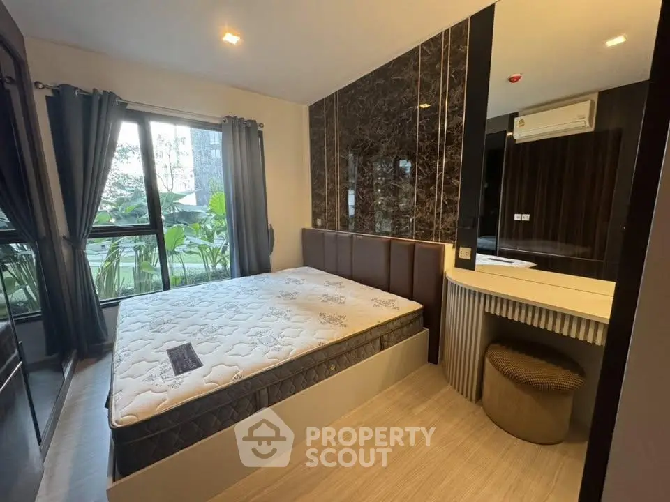 Modern bedroom with large window and stylish decor in a contemporary apartment.