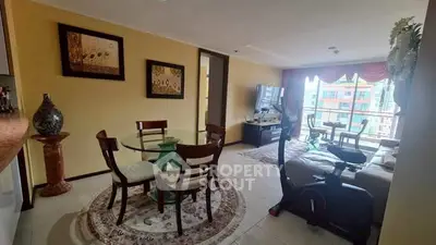 Spacious living room with elegant decor and city view, featuring dining area and exercise equipment.
