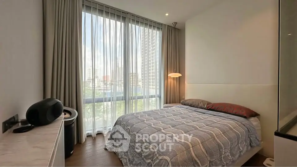 Modern bedroom with large window and stylish decor in urban apartment