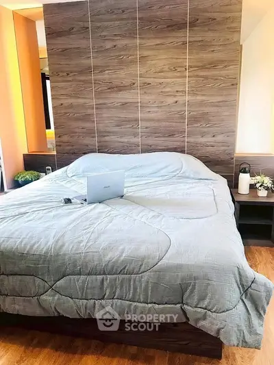 Modern bedroom with stylish wooden headboard and cozy bedding, perfect for relaxation.