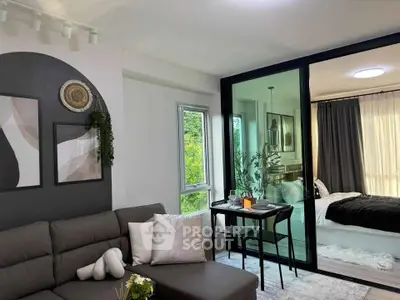 Modern open-plan living room with stylish decor and cozy bedroom view