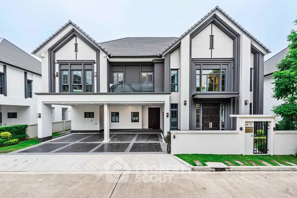 Modern two-story house with sleek design and spacious driveway in a suburban neighborhood.