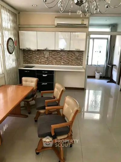 Spacious kitchen with modern design and dining area, featuring elegant chairs and stylish backsplash.