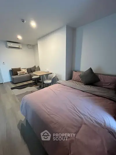 Cozy bedroom with modern decor and comfortable seating area, perfect for relaxation.