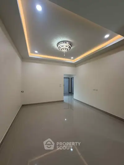 Spacious empty room with elegant ceiling lights and glossy tiled floor, perfect for customization.