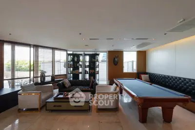 Luxurious living room with pool table and elegant seating area, perfect for entertainment and relaxation.