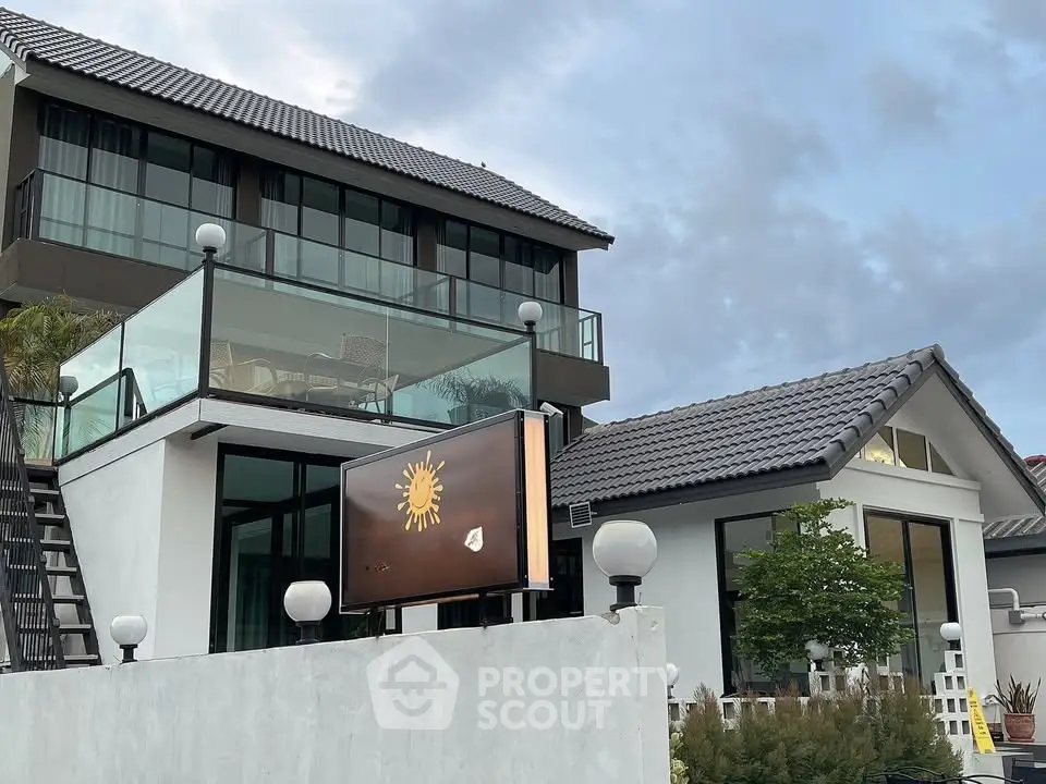 Modern two-story house with glass balcony and stylish architecture