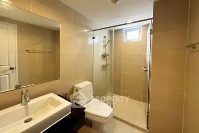Modern bathroom with glass shower and sleek fixtures in a contemporary home.