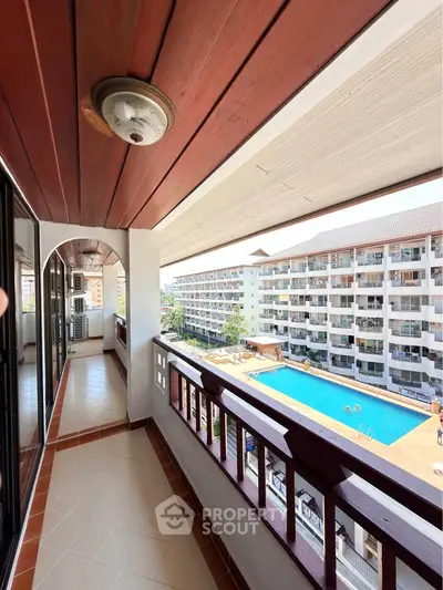 Spacious balcony with pool view in modern apartment complex