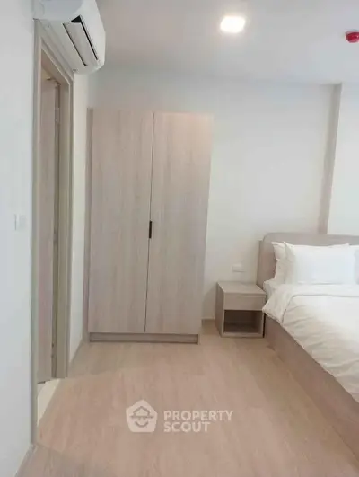 Modern bedroom with minimalist design featuring a sleek wardrobe and comfortable bed.
