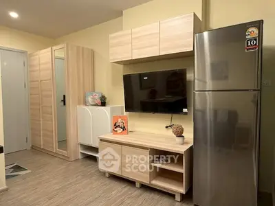 Modern living room with sleek wooden furniture and stainless steel fridge