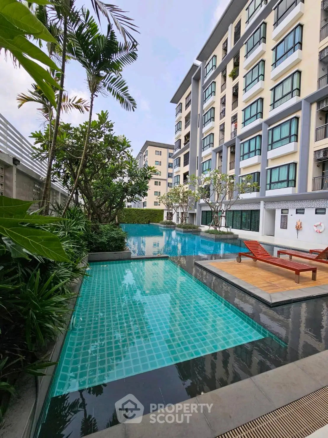 Luxurious condominium with stunning pool and lush greenery, perfect for relaxation and modern living.