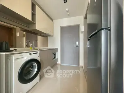 Modern kitchen with washing machine and sleek appliances in compact layout