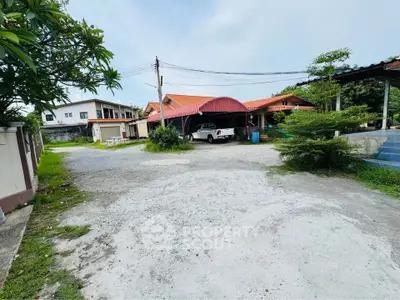 Spacious residential property with ample parking and lush greenery, ideal for family living.