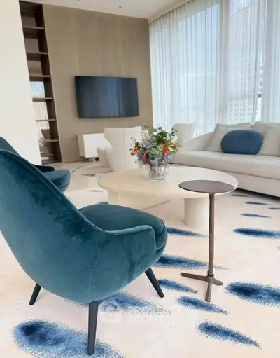 Luxurious modern living room with elegant furniture and large windows offering natural light.