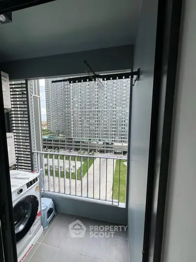 Modern apartment balcony with washing machine and city view, perfect for urban living.