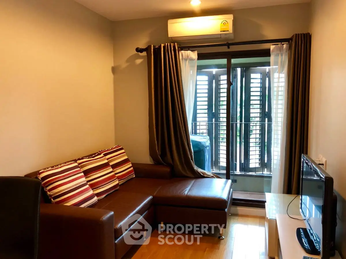 Cozy living room with modern sofa and balcony view, perfect for relaxation.