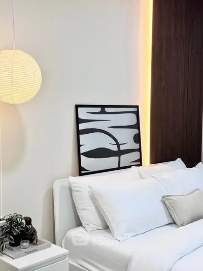 Modern bedroom with stylish decor and ambient lighting, featuring a cozy bed and contemporary artwork.
