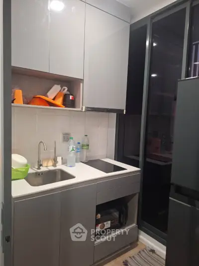 Modern compact kitchen with sleek cabinetry and built-in appliances