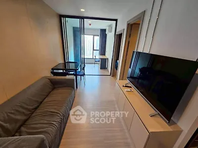 Modern living room with sleek furniture and large TV, featuring a spacious open layout and stylish decor.