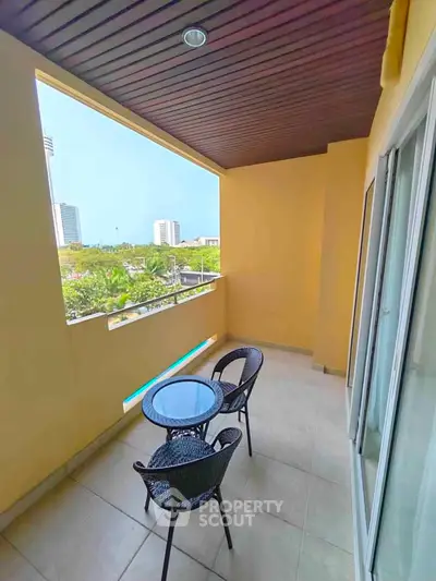 Spacious balcony with seating and city view, perfect for relaxation and outdoor dining.
