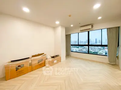 Spacious modern living room with large window offering stunning city views, perfect for urban living.