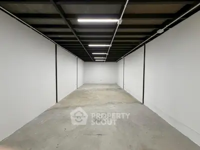 Spacious industrial-style storage unit with high ceilings and concrete floors.