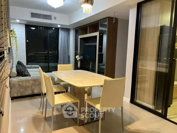 Modern dining area with elegant table and chairs, adjacent to cozy living room.