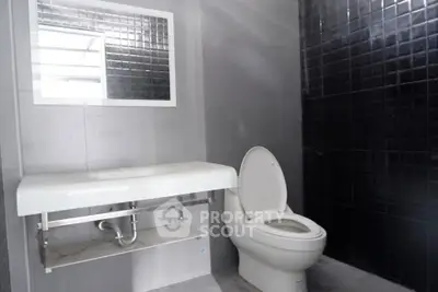 Modern bathroom with sleek black tiles and minimalist fixtures