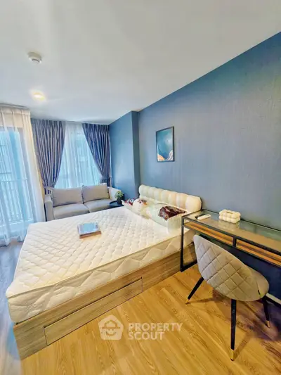 Modern bedroom with stylish decor, featuring a cozy bed, elegant desk, and large windows for natural light.