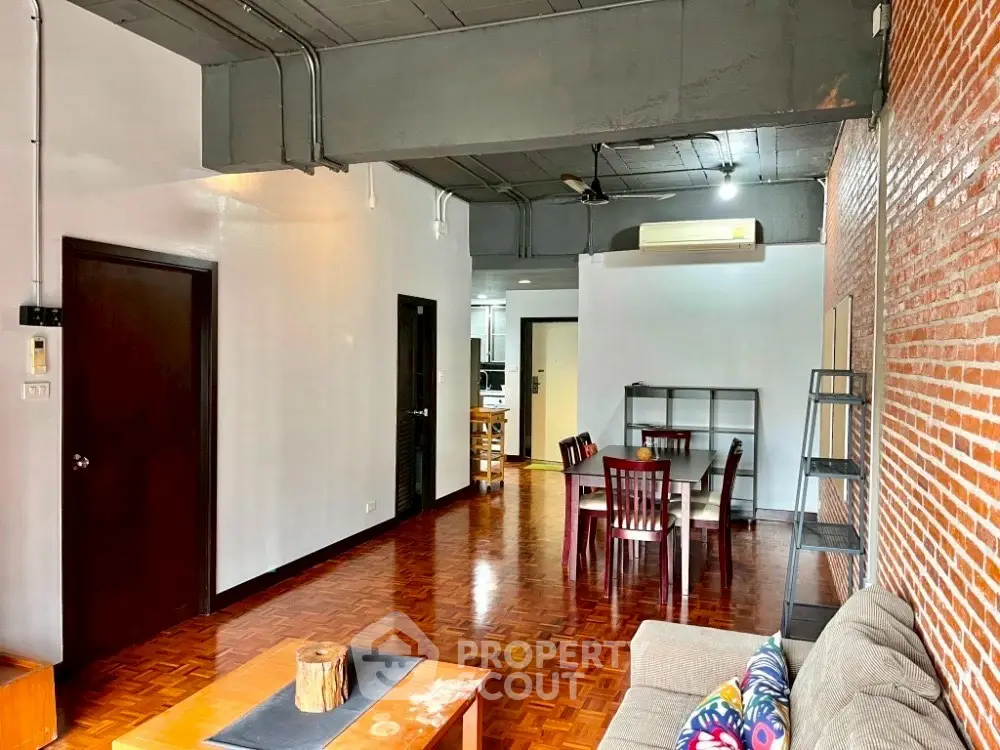 Spacious industrial-style living room with exposed brick and modern furnishings.