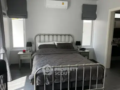 Modern bedroom with metal bed frame, air conditioning, and stylish decor